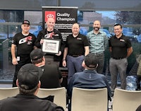 a group of men holding a certificate in front of a window